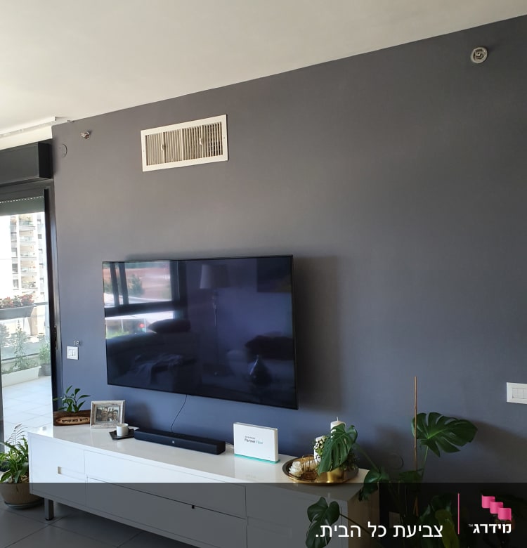 קיר צבוע בצבע אפור כהה עם טלוויזיה תלויה